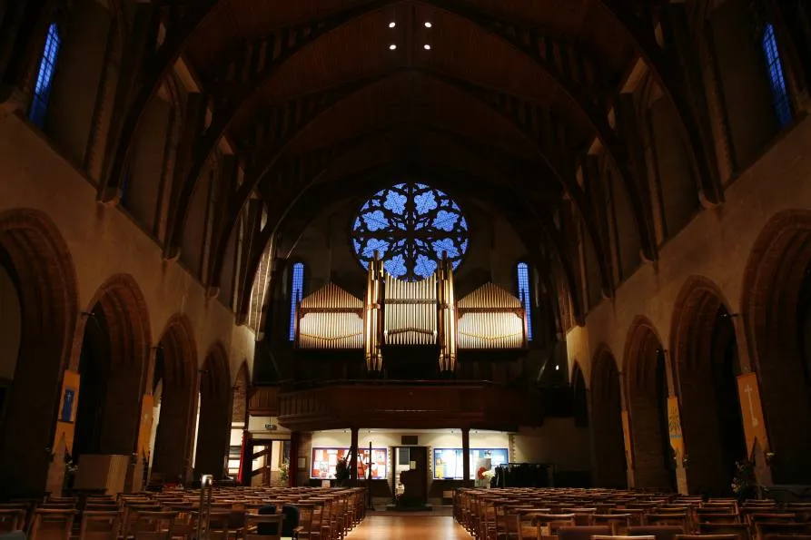 The organ in the west gallery of St Barnabas, its pipes rising above the rose window.