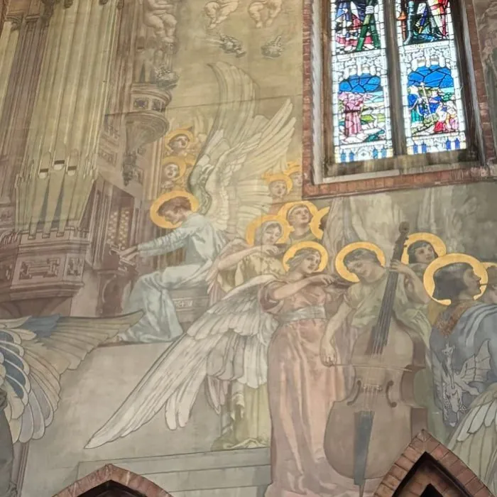 Detail of a church mural showing angel musicians playing a cello and organ