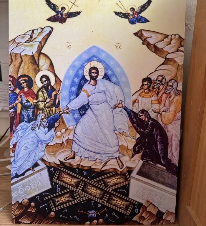 A printed icon of Christ's Resurrection propped against a wall