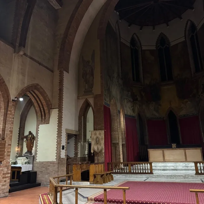 An empty side chapel with a lit statue, set up as a garden of repose