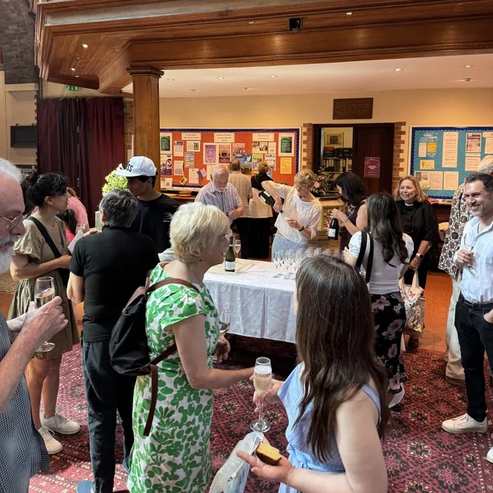 Parishioners gather with drinks at a birthday reception in the hall