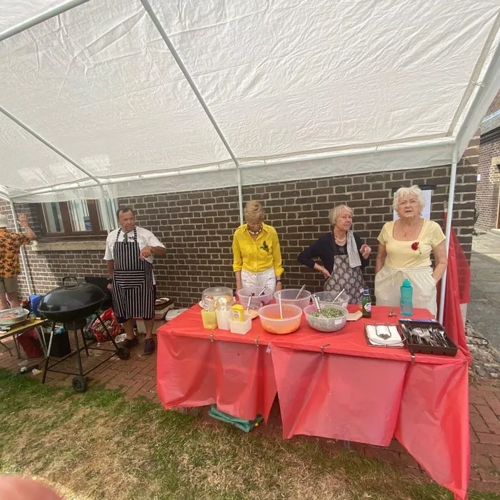 Volunteers preparing food under a marquee at the Summer Fayre